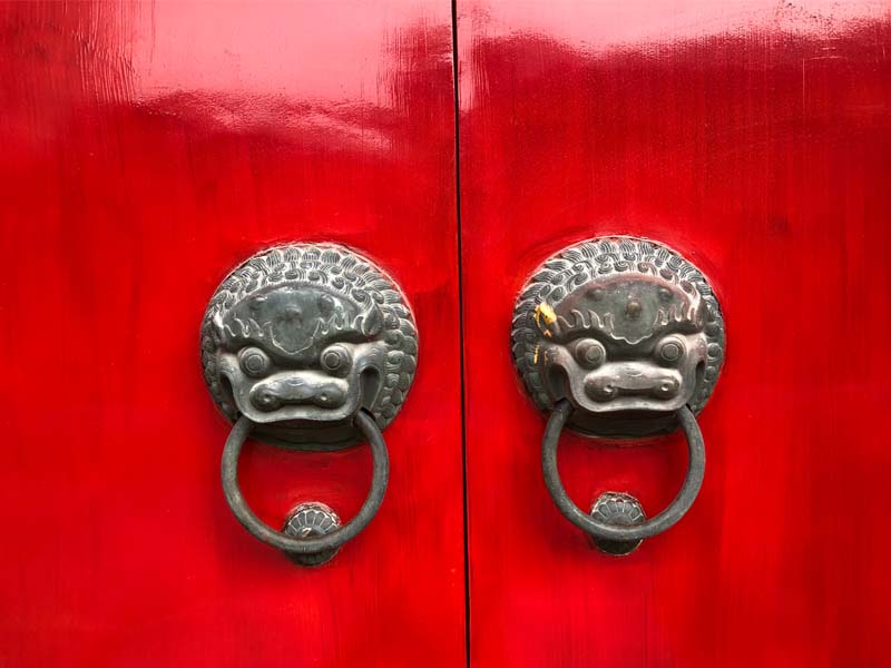 puerta roja china con manijas de dragón