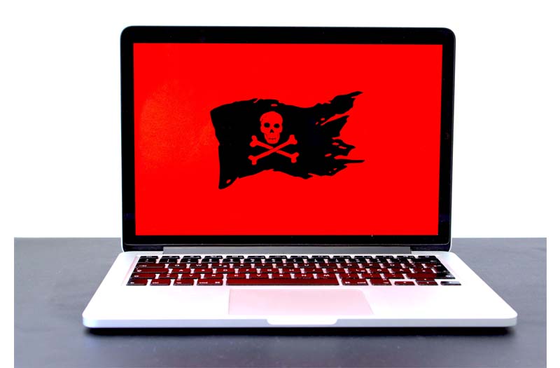 laptop con pantalla roja y bandera de pirata